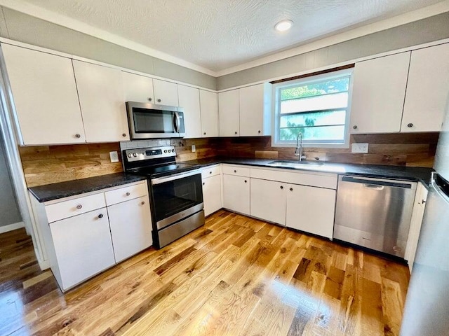 kitchen featuring light wood-type flooring, white cabinets, sink, and stainless steel appliances