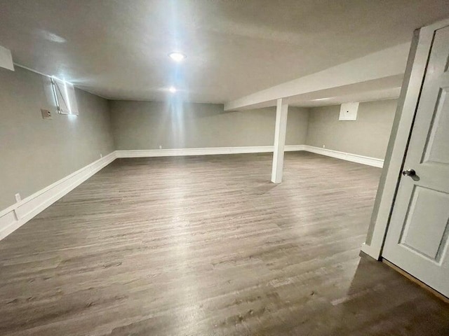 basement with dark hardwood / wood-style floors