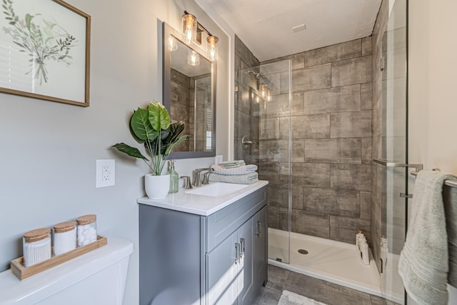 bathroom with toilet, vanity, and an enclosed shower