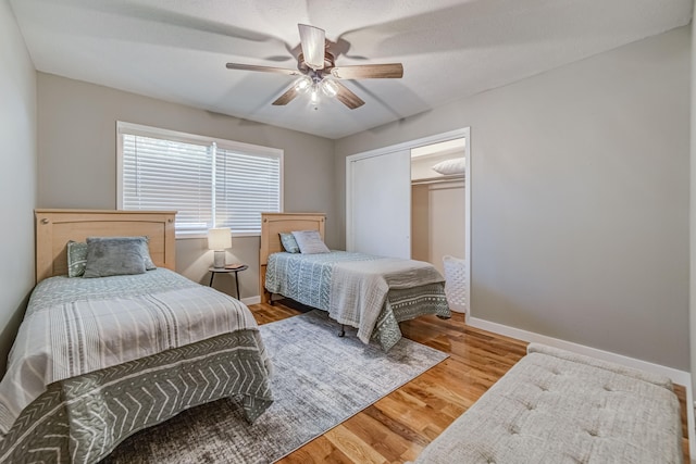 bedroom with ceiling fan, a closet, and wood-type flooring