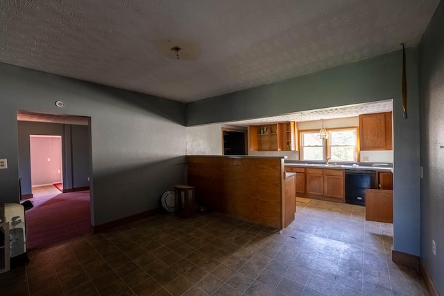 kitchen featuring a textured ceiling, sink, kitchen peninsula, and black dishwasher