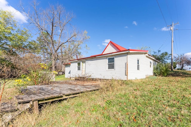 view of side of property featuring a yard and a deck