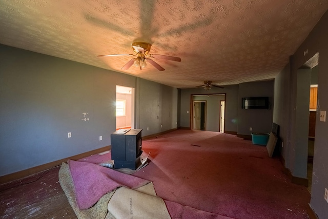 carpeted living room with a wood stove, a wall mounted air conditioner, ceiling fan, and a textured ceiling