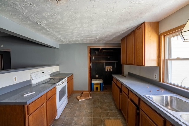 kitchen with plenty of natural light, a textured ceiling, and white range with electric cooktop