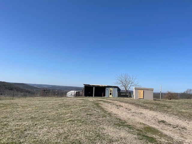 view of yard with an outbuilding and a rural view