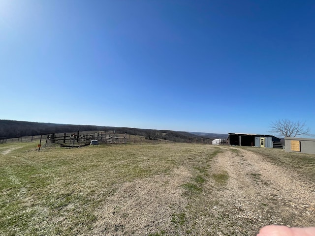 view of yard with a rural view and an outdoor structure