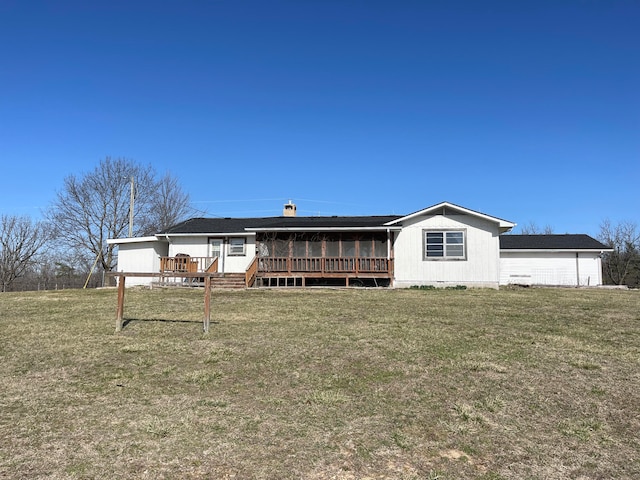 back of property featuring a lawn and a deck