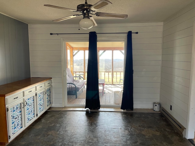 doorway to outside featuring wooden walls, a textured ceiling, and ceiling fan