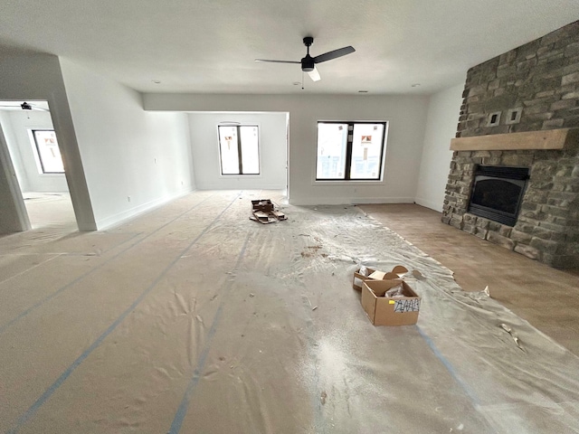 unfurnished living room featuring ceiling fan and a fireplace