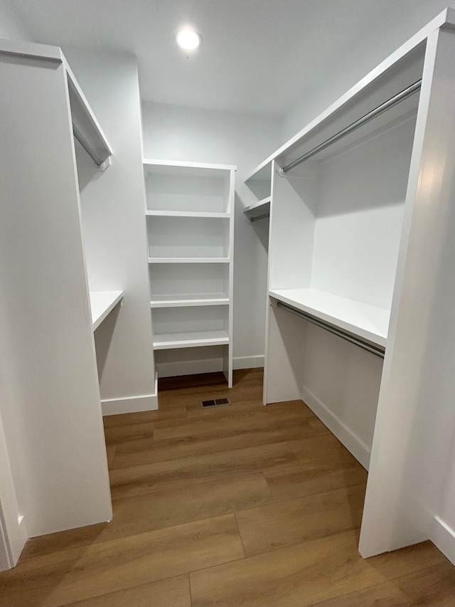 spacious closet with hardwood / wood-style flooring