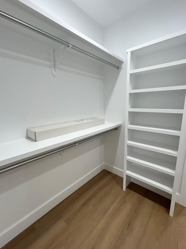 walk in closet with hardwood / wood-style floors