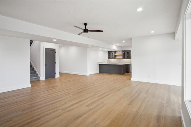 unfurnished living room with ceiling fan and light hardwood / wood-style floors