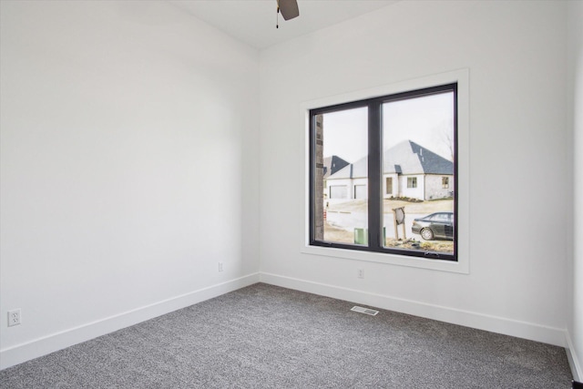 carpeted spare room with ceiling fan