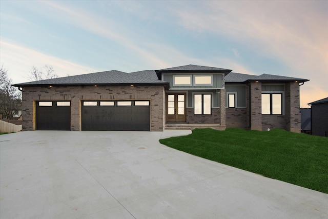 prairie-style house featuring a yard and a garage