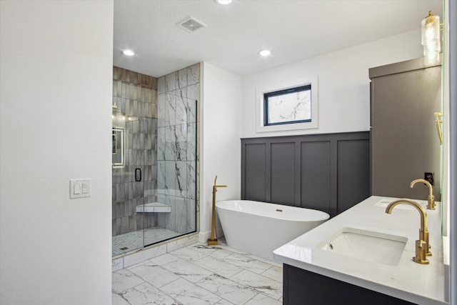 bathroom with independent shower and bath, vanity, and a textured ceiling