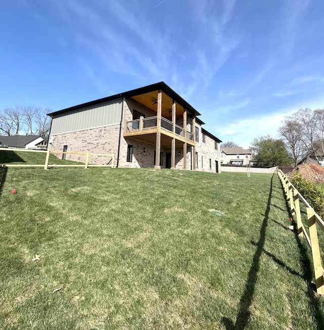 back of house featuring a lawn and ceiling fan