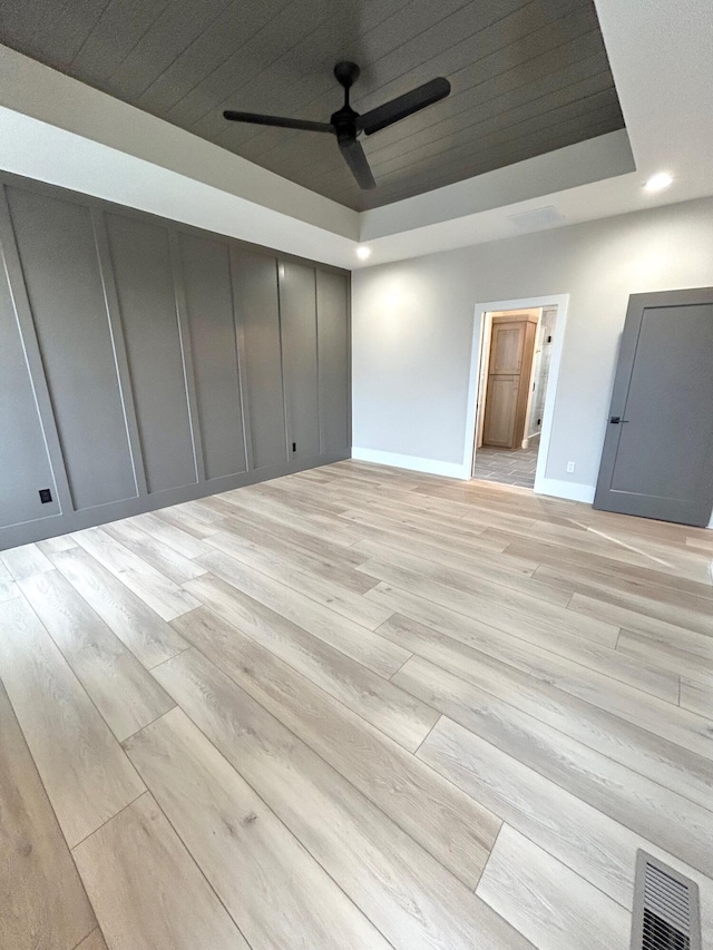 spare room featuring ceiling fan, wood ceiling, light hardwood / wood-style flooring, and a tray ceiling