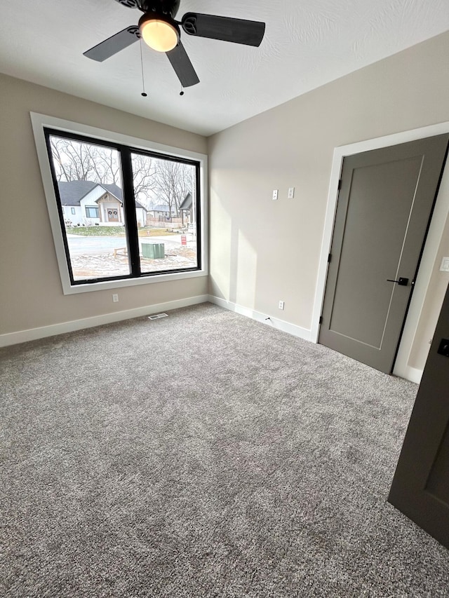 spare room featuring ceiling fan and carpet