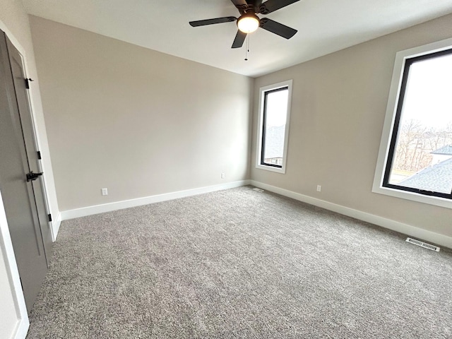 spare room featuring ceiling fan and carpet floors