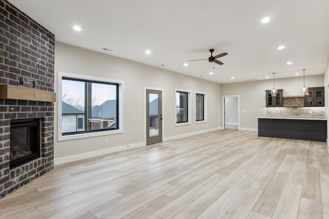 unfurnished living room featuring a fireplace, visible vents, recessed lighting, and light wood finished floors