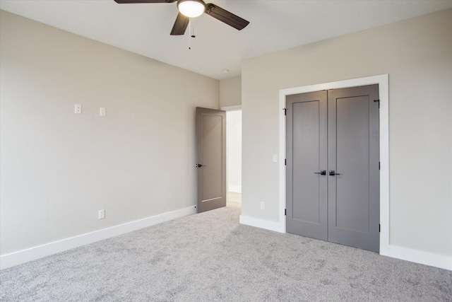 unfurnished bedroom featuring baseboards, carpet floors, ceiling fan, and a closet
