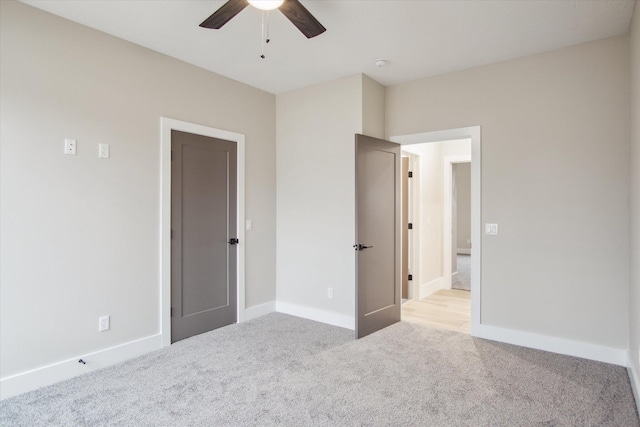 unfurnished bedroom featuring baseboards, ceiling fan, and light carpet
