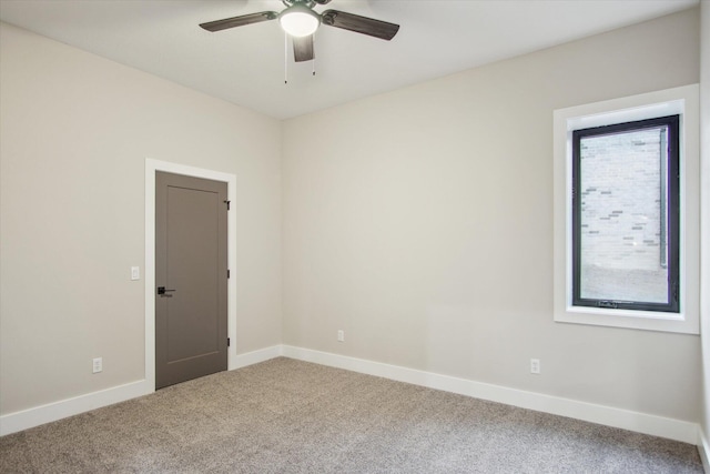 carpeted spare room with baseboards and ceiling fan