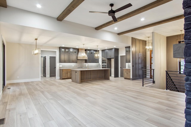 kitchen featuring open floor plan, light countertops, decorative backsplash, beamed ceiling, and custom exhaust hood