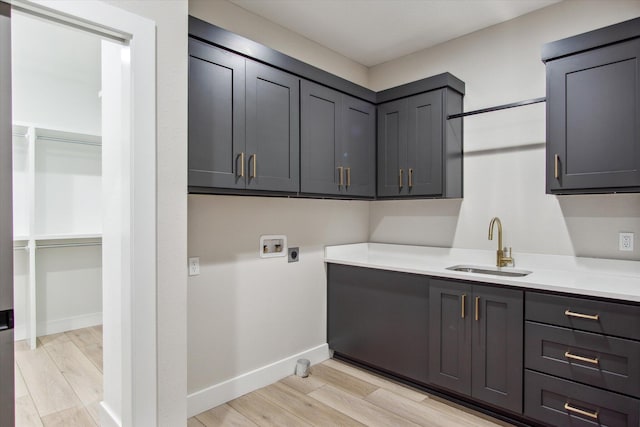 laundry area with hookup for an electric dryer, light wood-type flooring, hookup for a washing machine, a sink, and cabinet space