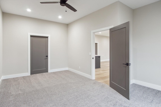 empty room with baseboards, ceiling fan, recessed lighting, and light colored carpet