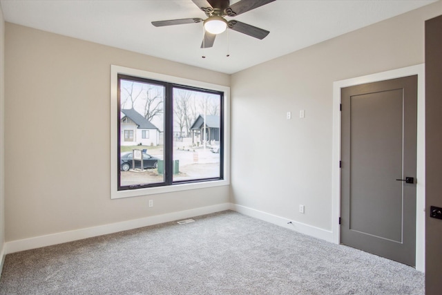 unfurnished room featuring baseboards, carpet flooring, ceiling fan, and visible vents