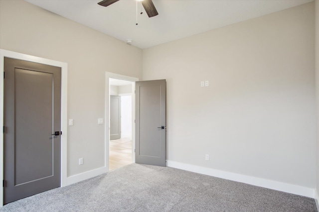 unfurnished bedroom with light carpet, baseboards, and ceiling fan