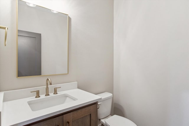 half bathroom with toilet and vanity