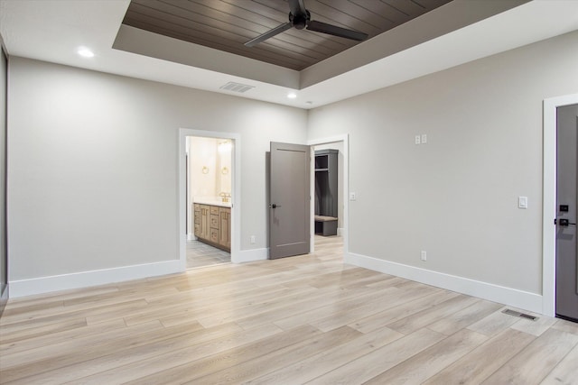 unfurnished bedroom featuring a raised ceiling, baseboards, visible vents, light wood-style floors, and recessed lighting