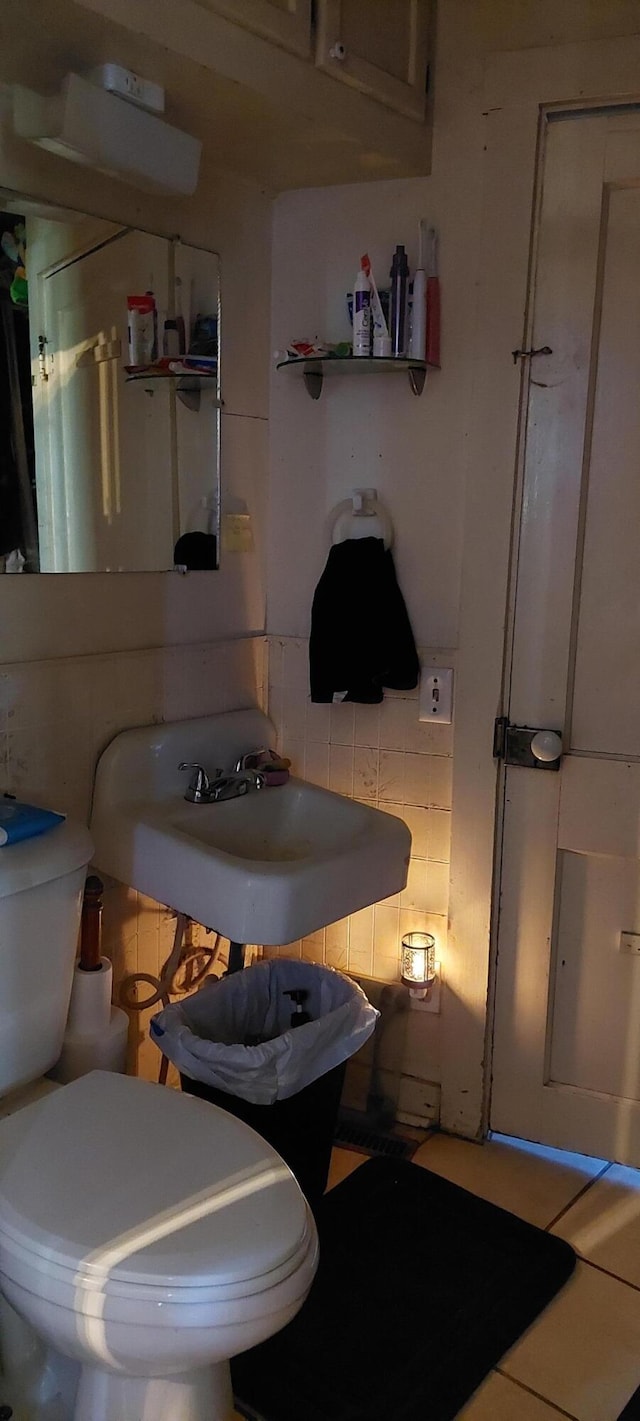 bathroom featuring sink, toilet, and backsplash