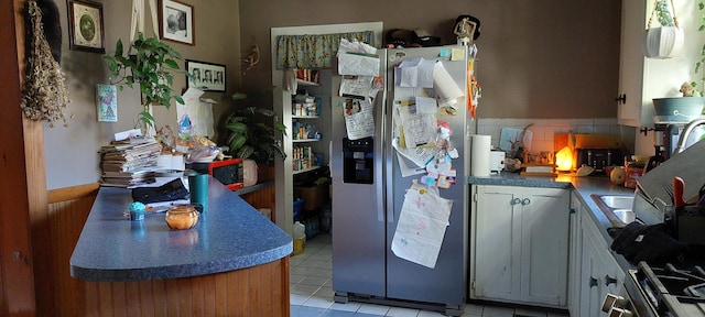 kitchen featuring tasteful backsplash, stainless steel fridge, and light tile patterned floors