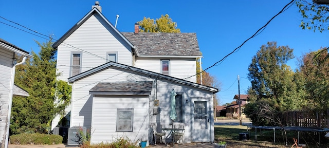 rear view of house with a trampoline and central AC