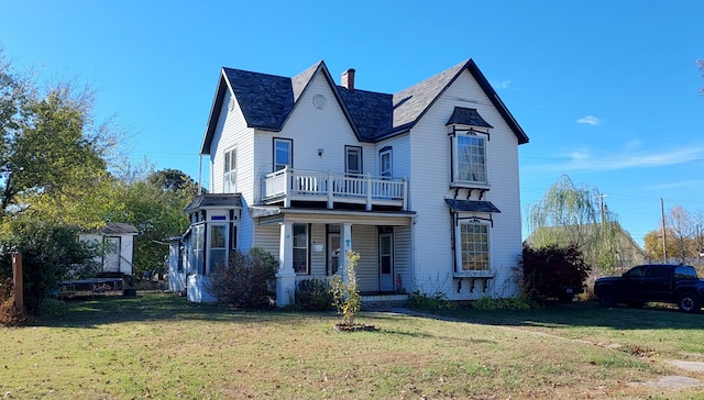 view of front of home with a balcony, a front lawn, and covered porch