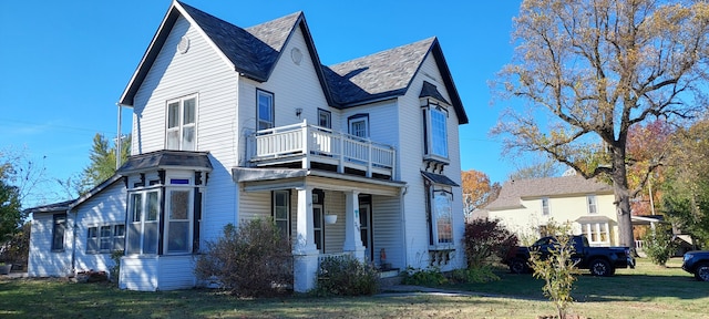 view of front facade featuring a front yard and a balcony