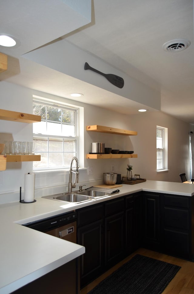 kitchen featuring sink, stainless steel dishwasher, kitchen peninsula, and wood-type flooring