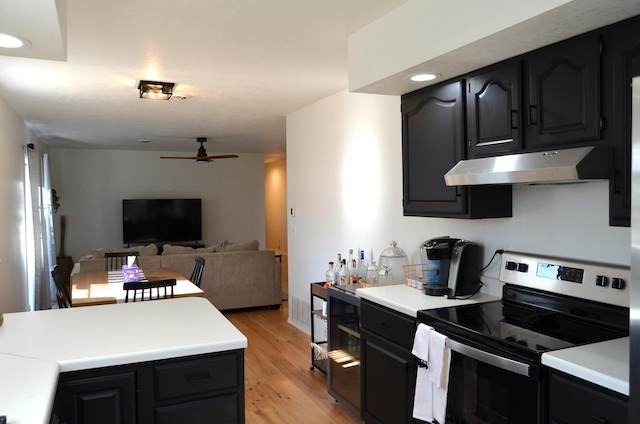 kitchen with light hardwood / wood-style floors, ceiling fan, and stainless steel electric stove