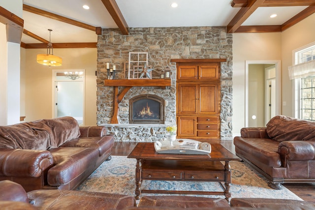 living room with a stone fireplace, beamed ceiling, and dark hardwood / wood-style floors