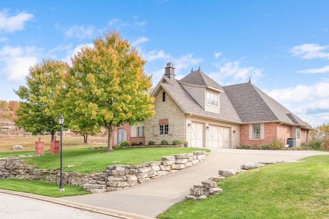 view of front of house featuring a garage, cooling unit, and a front lawn