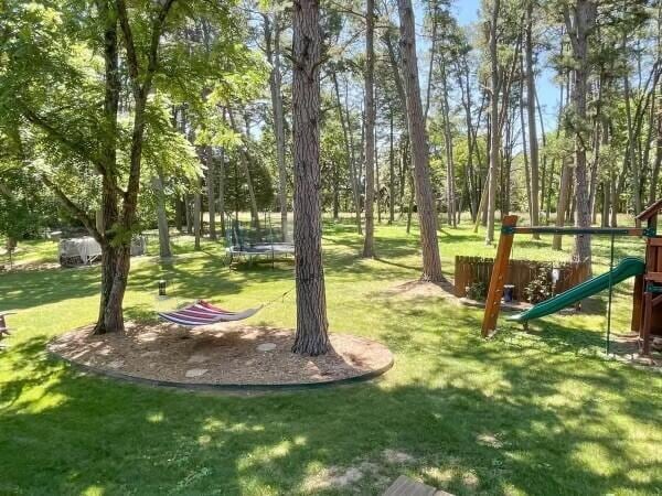 view of community with a yard, a playground, and a trampoline