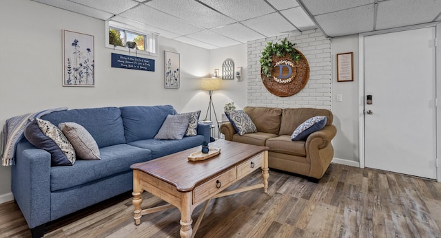 living room with a drop ceiling and hardwood / wood-style floors