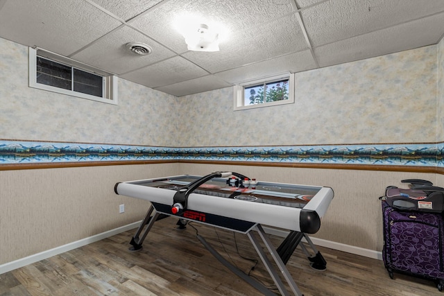 playroom with hardwood / wood-style floors and a drop ceiling