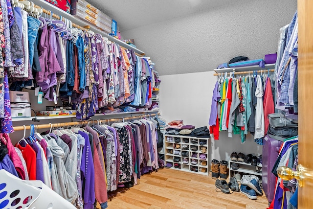 walk in closet featuring wood-type flooring and vaulted ceiling