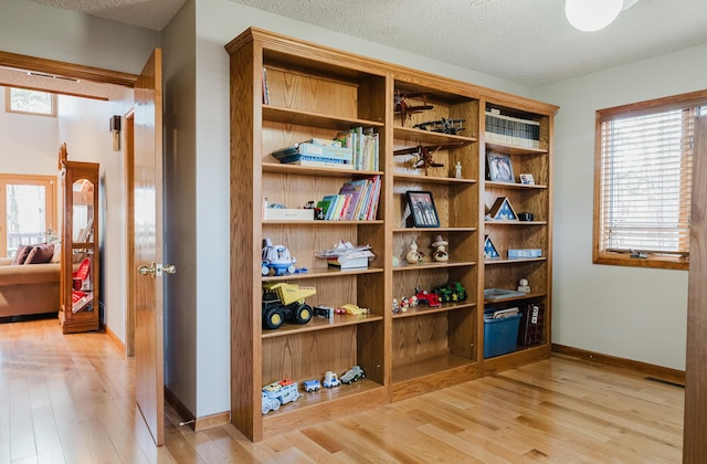 interior space with a textured ceiling and light wood-type flooring