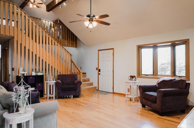 living room with light wood-type flooring, beamed ceiling, high vaulted ceiling, and ceiling fan