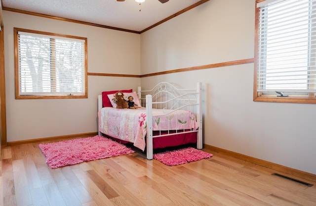 bedroom with ceiling fan, hardwood / wood-style flooring, and ornamental molding